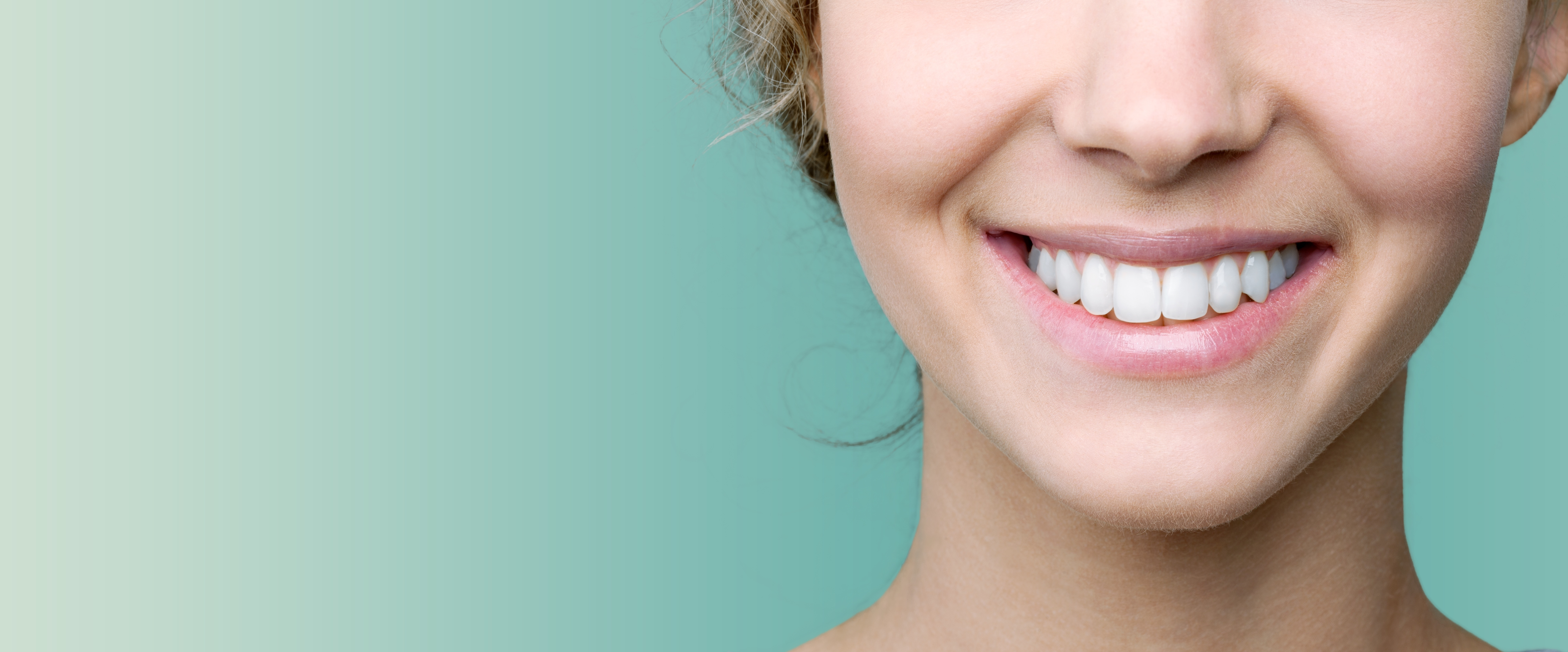 A smile, against a teal background, close-up