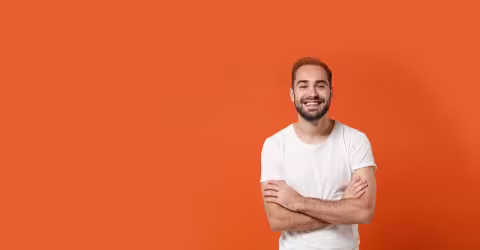A man arms crossed, against a orange background