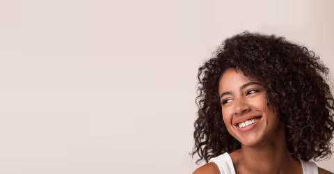 A woman curly hair, against a beige background