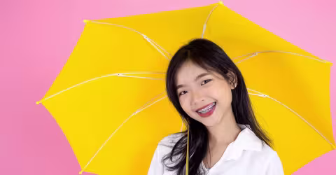 A woman umbrella pink, against a yellow background