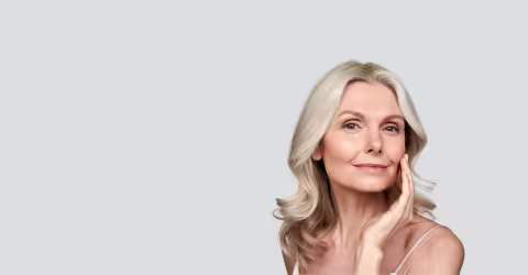 A woman hand on face, against a grey background